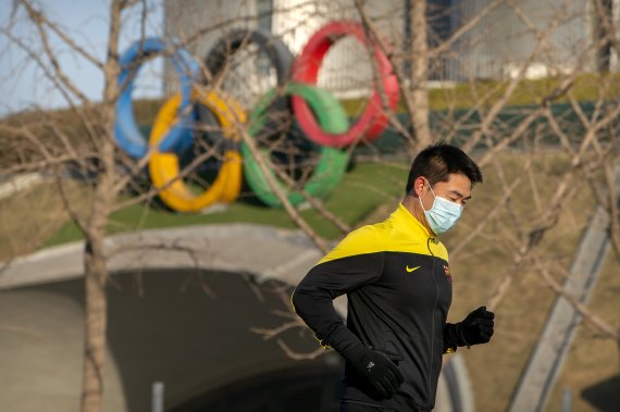 중국 베이징 올림픽 타워 앞에서 한 남성이 뛰고 있다. 중국은 2022년 베이징 동계올림픽 개최국이다. 뉴시스 제공
