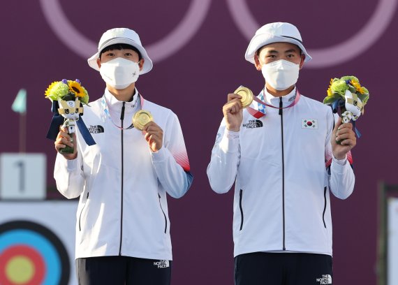 대한민국 양궁대표팀 안산(왼쪽)과 김제덕이 지난 24일 일본 도쿄 유메노시마 공원 양궁장에서 열린 2020 도쿄올림픽 혼성단체 결승전에서 승리해 금메달을 목에 걸고 포즈를 취하고 있다. / 사진=뉴스1