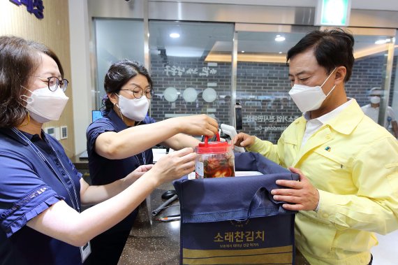 이강호 남동구청장은 남동구가 지역 특산품을 활용해 개발한 ‘소래찬’ 김치를 구입하고 있다.