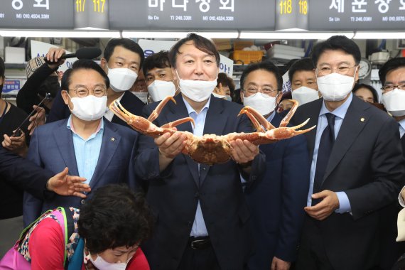 윤석열 전 검찰총장이 27일 오후 부산 중구 자갈치시장을 찾아 상인이 건넨 대게를 들어보이고 있다. 2021.7.27/뉴스1 © News1 여주연 기자