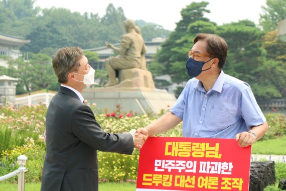 국민의힘 대권주자인 최재형 전 감사원장이 지난 29일 서울 종로구 청와대 앞 분수대 광장에서 드루킹 댓글 조작 사건 관련 문재인 대통령의 사과를 촉구하며 1인 시위를 벌이고 있는 정진석 국민의힘 의원을 찾아 인사하고 있다. / 사진=뉴시스(정진석 의원실 제공)