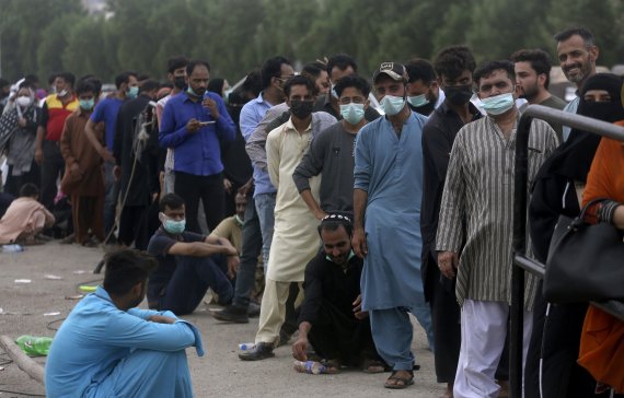 파키스탄 카라치에서 30일(현지시간) 중국산 시노백 코로나19 백신을 맞으려는 시민 수백명이 백신접종소 앞에 길게 늘어서 있다. AP뉴시스