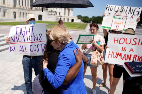 코리 부시 미국 민주당 대표와 엘리자베스 워렌 상원의원이 지난달 30일(현지시간) 국회의사당 밖에서 세입자 퇴거 유예 조치를 연장에 찬성하는 이들과 포옹하고 있다. /사진=뉴스1