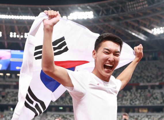 육상 국가대표 우상혁이 1일 오후 도쿄 올림픽스타디움에서 열린 2020 도쿄올림픽 남자 높이뛰기 결승전 경기에서 4위 2.35 한국신기록을 달성한 뒤 태극기를 들어보이고 있다. 뉴시스 제공