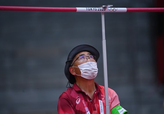 4일 일본 도쿄 올림픽 경기장에서 경기 관계자가 마스크를 쓰고 높이뛰기 경기를 준비하고 있다.로이터뉴스1