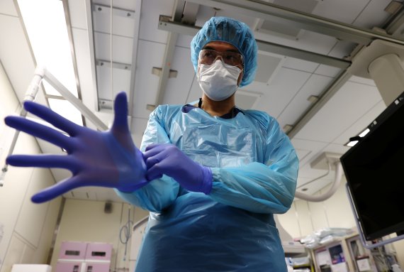 지난 1일 일본 도쿄의 한 대학병원 중환자실 담당 의사가 코로나19 진료 전 보호장구를 착용하고 있다. 로이터 뉴스1