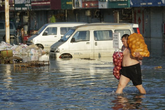 IPCC(기후변동에 관한 정부 간 협의체)에서 최근 발표한 보고서에서는 기후 변화가 이미 진행되었다며 비관적 전망을 내비쳤다. 사진은 중국 신샹에서 발생한 홍수 피해. AP뉴시스