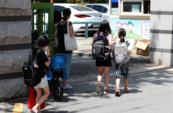 서울 한 초등학교에서 학생들이 온라인 개학식을 마치고 교과서를 받기 위해 등교하고 있다. 2021.8.9/뉴스1 © News1 구윤성 기자