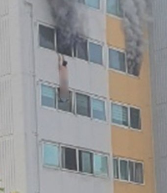 화재 당시 A씨가 창문에 매달려 있는 모습.(독자 제공).2021.8.2/© 뉴스1