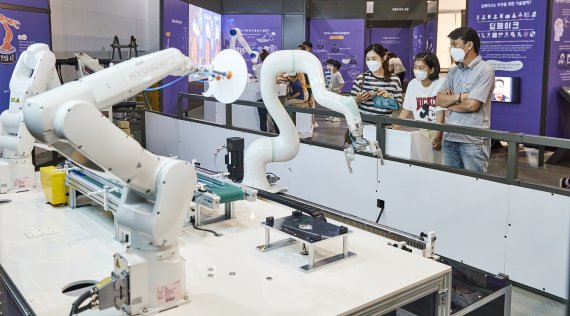 국립부산과학관 '헬로 로봇(HELLO ROBOT)' 특별전을 관람하는 시민들이 현대로보틱스의 산업로봇이 공장 자동화 공정에서 어떻게 일을 하는지 살펴보고 있다. 부산과학관 제공
