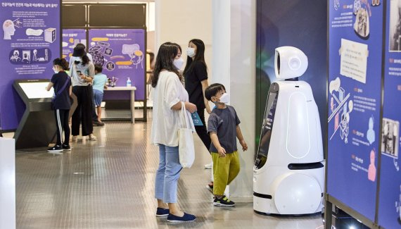 국립부산과학관 '헬로 로봇(HELLO ROBOT)' 특별전에 전시된 로봇이 관람객에게 전시장을 안내하고 있다. 부산과학관 제공