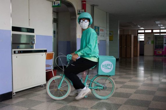 [의정부=뉴시스] 의정부고등학교 학생자치회가 공개한 졸업사진. 한 학생이 배달앱 서비스를 패러디 하고 있다. (사진=의정부고 학생자치회 제공)