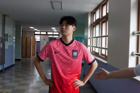 [의정부=뉴시스] 의정부고등학교 학생자치회가 공개한 졸업사진. 한 학생이 축구 국가대표 공격수 이동경이 올림픽에서 팀 패배 뒤 상대 선수의 악수를 거절해 '비매너 논란'이 제기됐던 장면을 패러디 하고 있다. (사진=의정부고 학생자치회 제공)