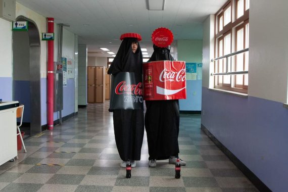 [의정부=뉴시스] 의정부고등학교 학생자치회가 공개한 졸업사진. 두명의 학생이 '코카콜라'로 분장하고 졸업사진에 촬영에 참여하고 있다. (사진=의정부고 학생자치회 제공)