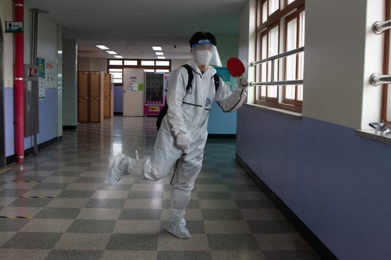 [의정부=뉴시스] 의정부고등학교 학생자치회가 공개한 졸업사진. 한 학생이 '2020도쿄올림픽' 국가대표 탁구선수 신유빈이 인천공항에서 방역복을 입었던 모습을 패러디 하고 있다. (사진=의정부고 학생자치회 제공)