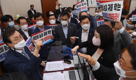 19일 오후 서울 여의도 국회 문화체육관광위원회 전체회의에서 국민의힘 의원들이 언론중재법 개정안 통과시키려는 도종환 위원장의 회의 진행를 막아서고 있다. 더불어민주당은 이날 고의·중과실로 허위·조작 보도를 할 경우 최대 5배의 징벌적 손해배상을 하도록 하는 언론중재법 개정안을 국민의힘의 반발 속에 단독 처리했다. 사진=박범준 기자