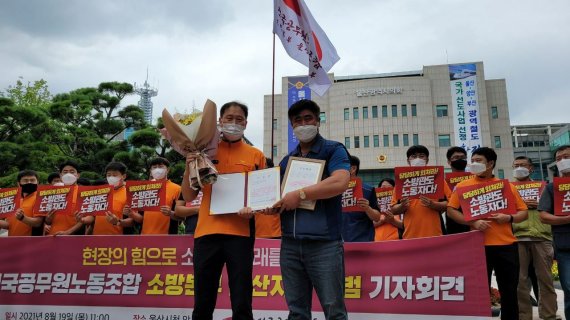 전국공무원노동조합 소방본부 울산지부 출범식이 19일 오전 울산시청 앞에서 열렸다. 김동욱 초대 지부장(온산소방서 온산 119안전센터, 사진 왼쪽)이 조합원을 대표해 축하 꽃다발을 받고 있다. /사진=민주노총 울산지역본부 제공