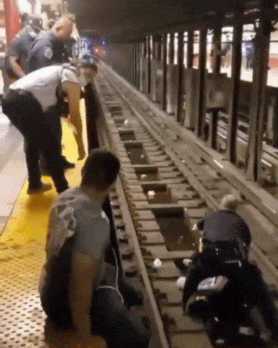 미국 뉴욕 지하철 선로로 추락한 남성을 구하기 위해 경찰과 시민이 힘을 모았다. (뉴욕경찰 페이스북 갈무리) © 뉴스1