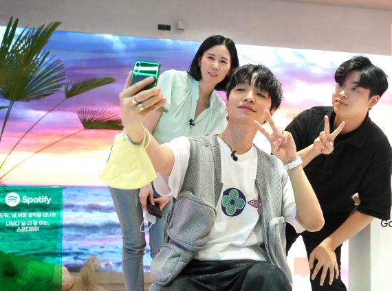 LG유플러스가 지난 23일 개최한 1호 개통 전달식에서 사이먼 도미닉(가운데)이 갤럭시Z플립3을 체험하고 있다. LG유플러스 제공