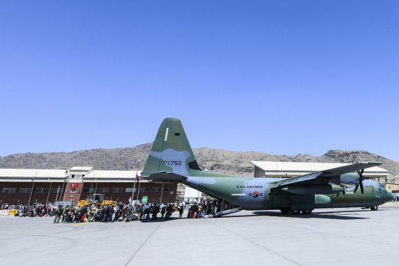 한국으로 이송될 아프간인 현지 조력자와 가족들이 지난 2021년 8월 25일(현지시간) 아프가니스탄 카불공항에서 공군 C-130J 수송기에 탑승하고 있다.<div id='ad_body3' class='mbad_bottom' ></div> 사진=공군 제공