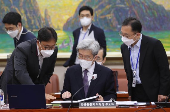 고승범 금융위원장 후보자가 27일 오전 서울 여의도 국회 정무위원회 전체회의에서 열린 인사청문회에 출석해 청문회 시작을 기다리며 관계자와 대화하고 있다./사진=박범준 기자