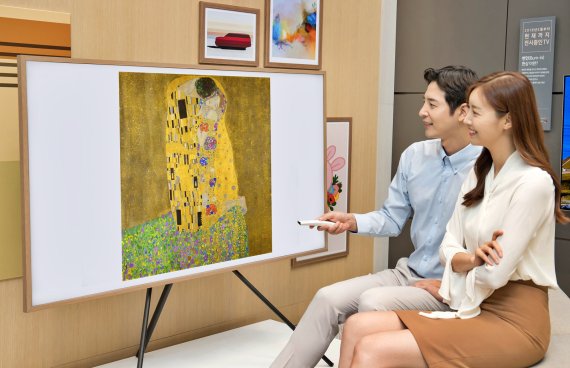 삼성전자 모델들이 '더 프레임' 75형 TV로 구스타프 클림트의 '키스(The Kiss)'를 감상하고 있다. 삼성전자 제공