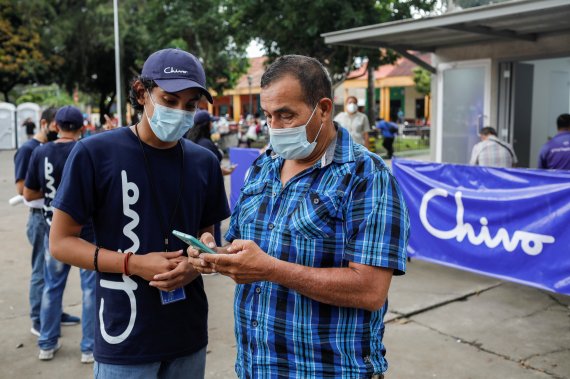 8일(현지시간) 엘살바도르 산타테클라에서 비트코인 디지털 지갑 앱 인 '치보' 전문가(왼쪽 세번째)가 비트코인 인출기 앞에서 한 시민에게 앱 사용법을 가르치고 있다.로이터뉴스1