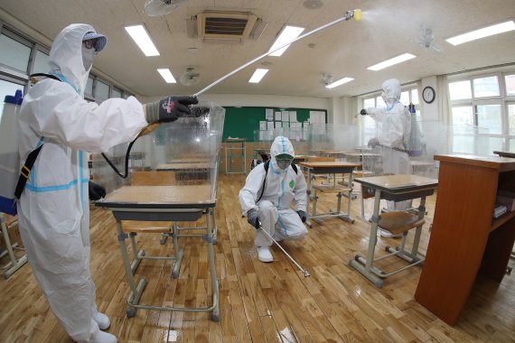 지난달 16일 오후 개학을 하루 앞둔 대구 수성구의 한 고교에서 방역요원들이 코로나19 예방을 위해 교실 구석구석을 소독하고 있다. 2021.8.16/뉴스1 © News1 공정식 기자