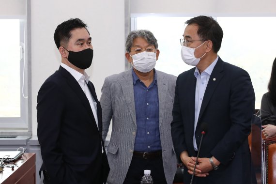 지난 9일 국회에서 열린 언론중재 및 피해구제 등에 관한 법률(언론중재법)’ 개정안 여야 협의체 회의에서 김종민 더불어민주당 의원(왼쪽)과 최형두 국민의힘 의원이 대화하고 있다. 가운데는 문재완 한국외국어대 법학전문대학원 교수. 뉴스1.