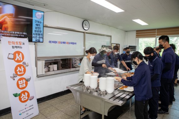 지난 9일 한화토탈 고객사인 삼동산업 구내식당에서 직원들이 서산 특산물로 만든 음식을 배식받고 있다. 한화토탈 제공.