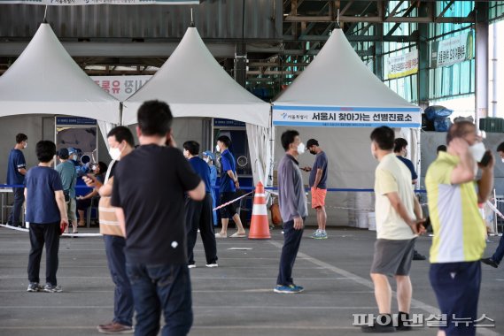 가락시장에서 코로나19 확진자가 잇따라 나오고 있는 가운데 12일 서울 송파구 가락농수산물종합도매시장에 설치된 찾아가는 선별진료소를 찾은 시장 상인과 시민들이 코로나19 검사를 받기 위해 줄 서 있다. 사진=서동일 기자