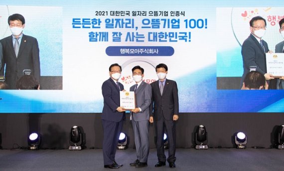 2021 대한민국 일자리 으뜸기업 인증식에서 행복모아㈜ 조상욱 대표(가운데)가 대통령 명의의 인증패를 받고 있다.(SK하이닉스 제공)© 뉴스1