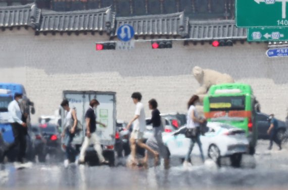서울 종로구 광화문 인근 횡단보도를 건너는 시민들 앞으로 아지랑이가 피어오르고 있다. 2020.6.9/뉴스1 © News1 이성철 기자