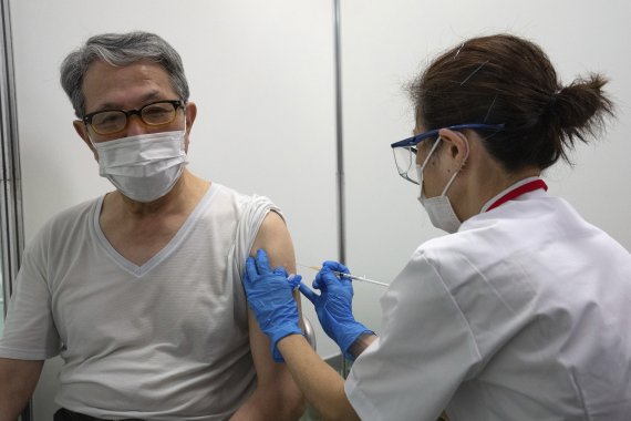 [도쿄=AP/뉴시스]24일 일본 도쿄에 새로 개소한 코로나19 대량접종센터에서 한 노인이 모더나 백신을 접종하고 있다. 일본은 하루 최대 1만5000명의 노인을 대상으로 도쿄와 오사카 두 곳에 대량접종 센터를 개설했다. 2021.05.24. /사진=뉴시스