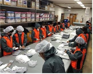 지난해 3월 부산 사하구 한 마스크 제조 공장에서 의용소방대원들이 지원활동을 하고 있다.(부산소방재난본부 제공) © 뉴스1