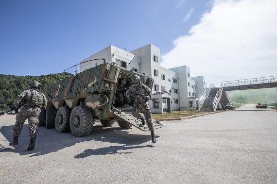 Army TIGER 4.0 전투실험 현장에서 워리어플랫폼을 착용한 전투원들이 K808 차륜형장갑차에서 하차한 후 적진으로 진입하고 있다. 육군 제공