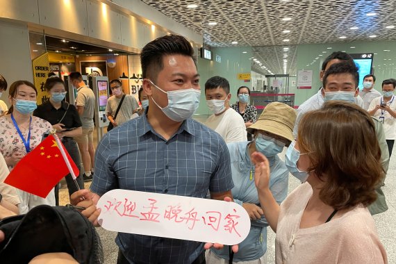25일 선전 바오안 공항에서 한 시민이 '멍완저우의 귀국을 환영한다'는 팻말을 들고 있다. © 로이터=뉴스1 © News1 박형기 /사진=뉴스1