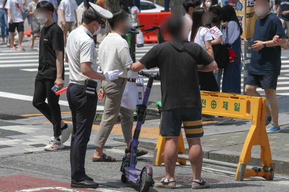 서울 시내에서 경찰이 헬멧을 미착용한 공유형 전동 킥보드를 이용자를 단속하고 있다. 2021.6.13/뉴스1 © News1 성동훈 기자
