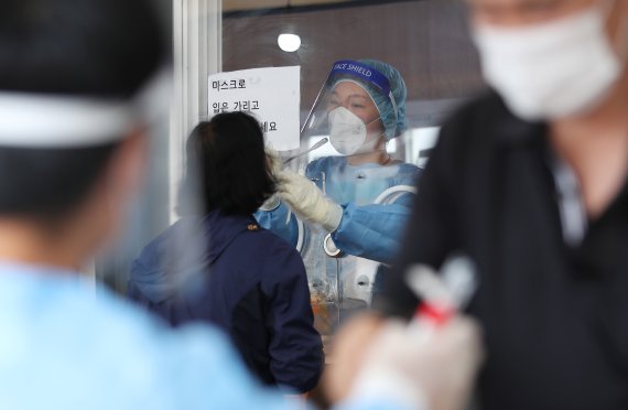 지난달 28일 오전 서울 중구 서울역 광장에 마련된 코로나19 임시선별검사소를 찾은 시민들이 검체 검사를 받고 있다. 뉴스1 제공.