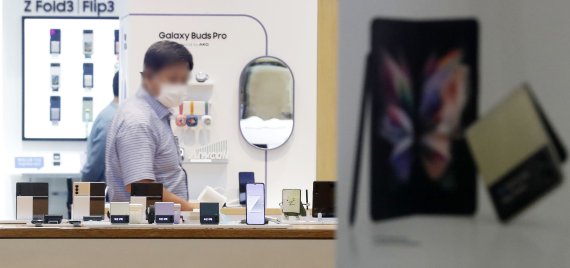 [서울=뉴시스] 홍효식 기자 = 지난달 27일 공식 출시한 갤럭시Z폴드3·플립3이 한 달이 지난 지금까지 물량 부족으로 공급 지연 현상이 빚어지고 있는 29일 오후 서울 서초구 삼성전자 서초사옥 딜라이트 샵에서 한 시민이 갤럭시Z폴드3·플립3를 살펴보고 있다. 2021.09.29. yesphoto@newsis.com