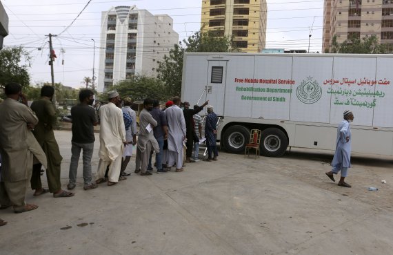 [카라치=AP/뉴시스] 6일(현지시간) 파키스탄 카라치에서 시민들이 시노백 백신 접종을 위해 이동식 백신 차량 앞에 줄 서 있다. 2021.08.06.