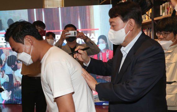 [서울=뉴시스] 국회사진기자단 = 국민의힘 대권주자인 윤석열 전 검찰총장이 3일 서울 강남구 최인아책방에서 열린 국민캠프 청년위원회 임명장 수여식에서 한 참석자의 등에 사인을 해주고 있다. 2021.10.03. photo@newsis.com