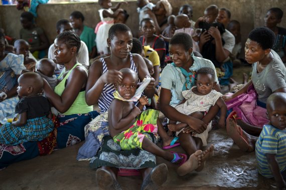 세계보건기구(WHO)가 6일(현지시간) 세계최초의 말라리아 백신 사용을 승인한 가운데 백신 접종 시범 프로그램이 진행 중인 아프리카 말라위에서 2019년 12월 11일 토말리 주민들이 아이들에게 백신을 맞히기 위해 기다리고 있다. AP뉴시스