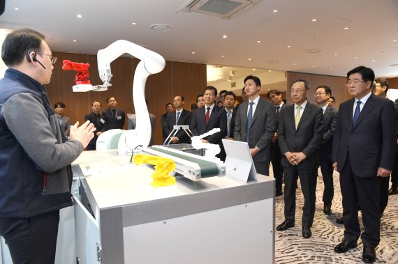 [서울=뉴시스] (오른쪽부터)권오갑 현대중공업그룹 회장과 황창규 KT 회장, 정기선 현대중공업지주 부사장이 2019년 12월 열린 ‘5G 기반 사업 협력 성과 발표회’에서 AI 음성 인식 협동 로봇 시연을 보고 있다. (사진=현대중공업그룹 제공) *재판매 및 DB 금지