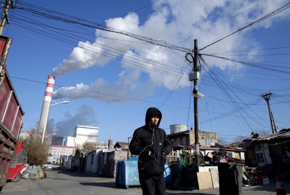 한 시민이 중국 헤이룽장성 하얼빈에 위치한 석탄 화력 발전소 인근을 걸어가고 있다. © 로이터=뉴스1 © News1 박형기