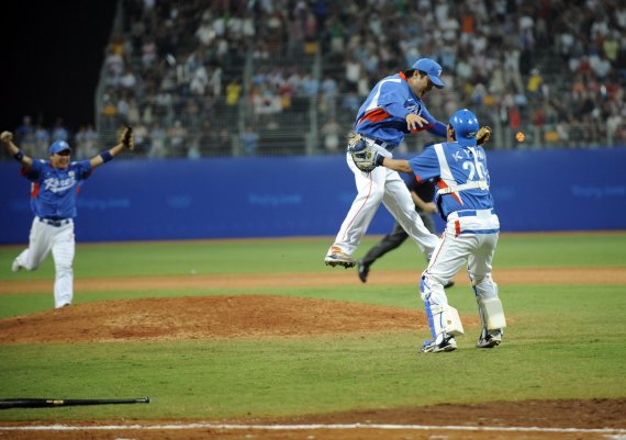 【베이징=신화/뉴시스】 23일 저녁 베이징우커송야구장에서 열린 야구 결승 한국과 쿠바의 경기에서 우승한 한국 선수들이 얼싸안으며 기뻐하고 있다.