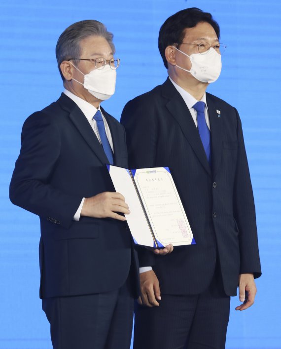 [서울=뉴시스] 국회사진기자단 = 더불어민주당 제20대 대통령 후보에 선출된 이재명 후보가 10일 서울 송파구 올림픽공원 핸드볼경기장에서 열린 서울 합동연설회에서 후보자 추천서를 받은 뒤 송영길 대표와 기념촬영을 하고 있다. 2021.10.10. photo@newsis.com