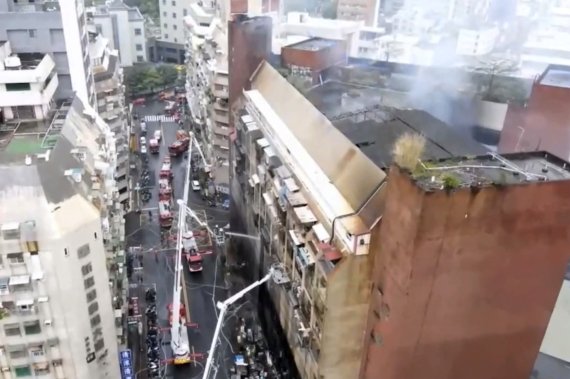 [가오슝=AP/뉴시스] 14일 대만 남부 가오슝의 13층짜리 주상복합 건물에서 불이 나 소방관들이 건물 내부에 물을 뿌리고 있다. 소방 당국은 이날 새벽 청충청 빌딩에서 불이나 오전 7시경 불을 껐으며 최소 9명이 숨지고 44명이 다쳤다고 밝혔다. 2021.10.14.