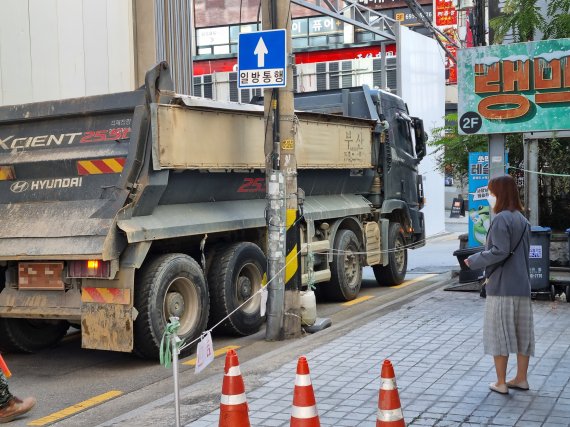 지난 14일 오전 8시30분쯤 서울 강남구의 한 골목길을 걸어가던 시민이 공사장 덤프트럭이 다가오자 몸을 피하고 있다. 사진=김해솔 기자