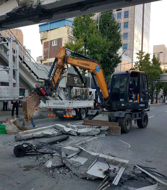 [광주=뉴시스] 변재훈 기자 = 18일 오전 4시30분께 광주 북구 북동 모 초등학교 앞 육교에 건설 중장비인 집게차가 충돌했다. 이 사고로 약 4.3m 높이 교량 하부 콘크리트 구조물이 파손돼 도로로 추락하고 일부 균열이 발생, 행정당국이 응급 복구에 나섰다. (사진=독자 제공) 2021.10.18. photo@newsis.com *재판매 및 DB 금지